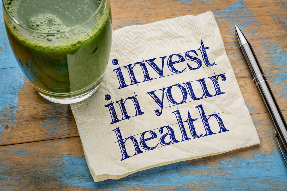 Green smoothie next to a napkin with the phrase invest in your health, promoting nourishing body inside out