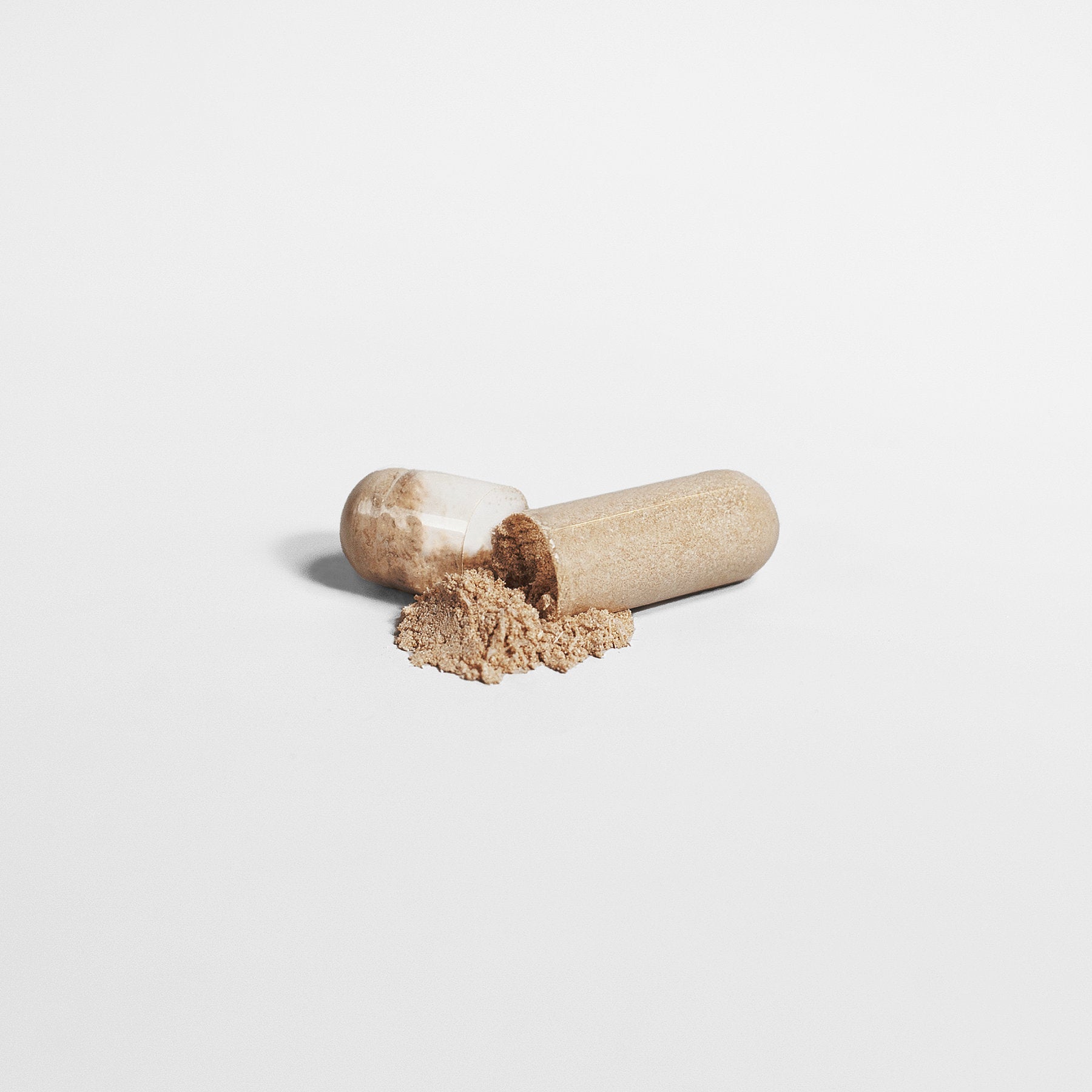 Alpha Omega Vitality Mushroom Complex Supplement in a capsule with spilled powder